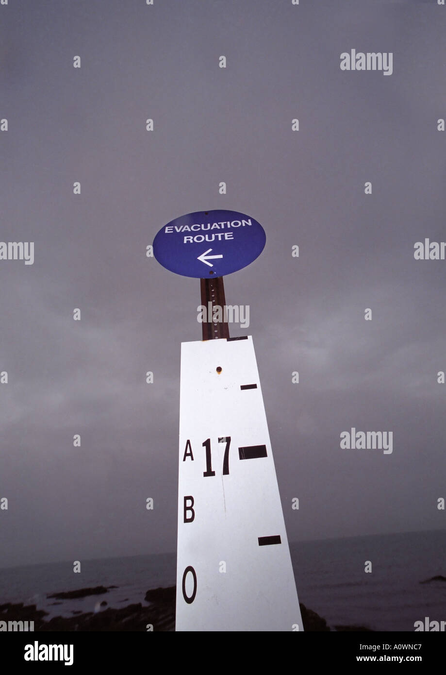 Flood evacuation sign with water and ocean in background Stock Photo