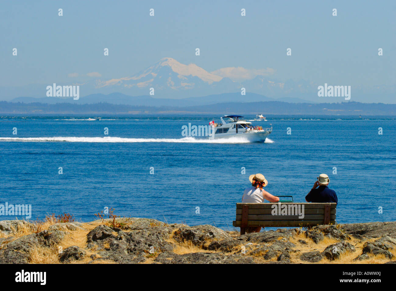 Senior couple enjoying summer afternoon view of Mt. Baker and boating activity on Juan de Fuca Strait-Victoria, British Columbia Stock Photo