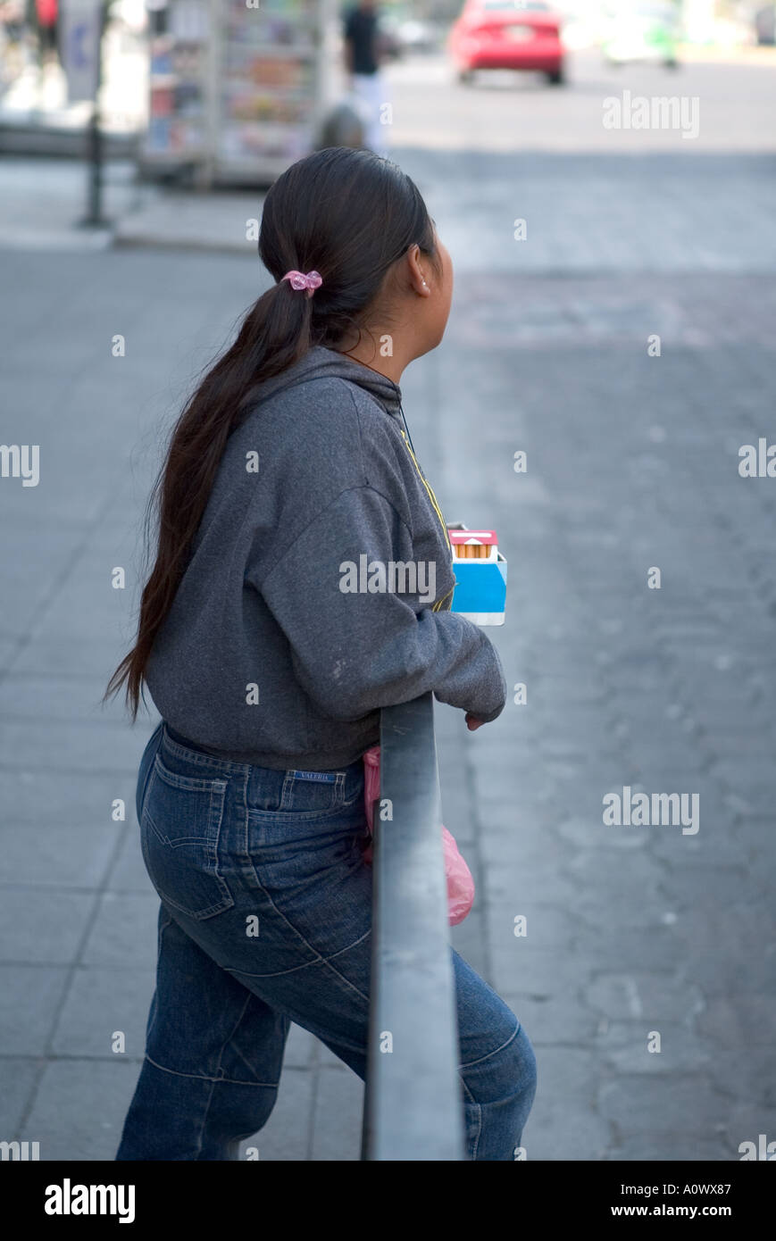 Woman selling cigarettes and other goods beside the road in Mexico City Stock Photo