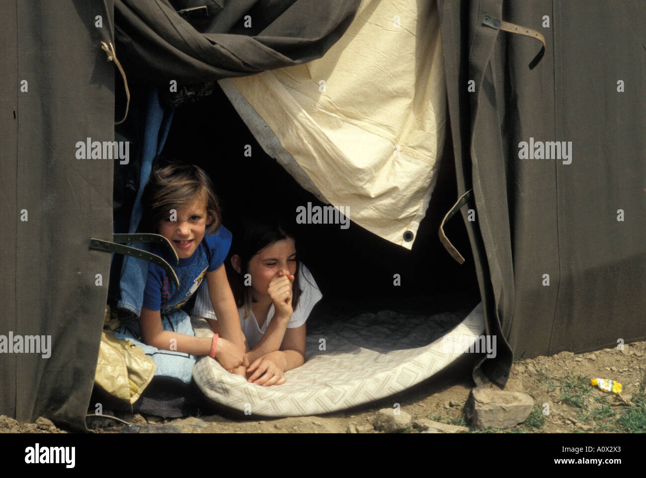 Two sisters in army camp at refugee camp set up in Macedonia for Kosovo refugees Stock Photo