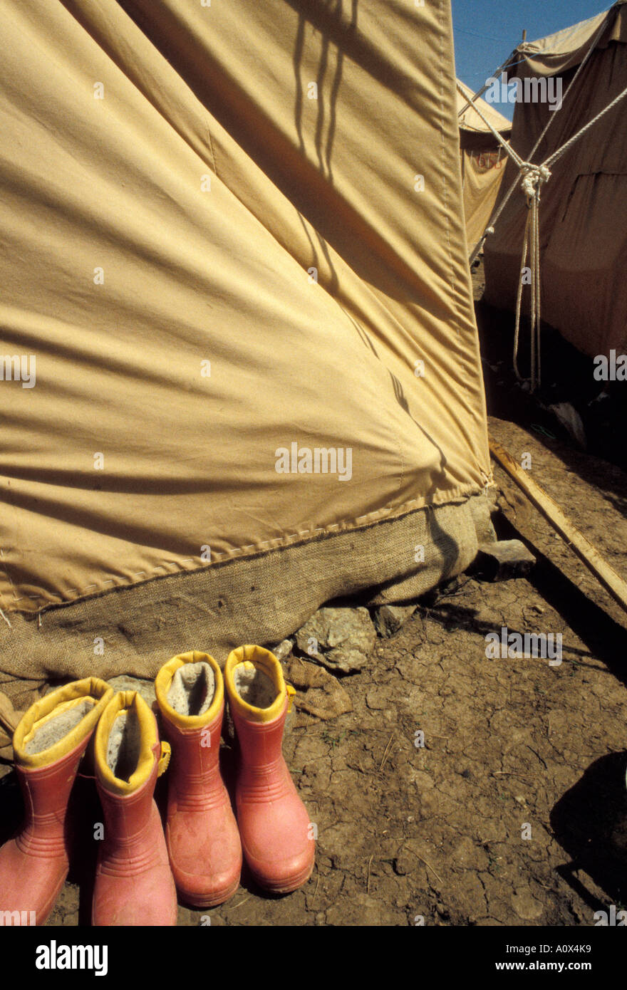 Army tent set up for Kosovo refugess in Macedonia during the Kosovo conflict with childrens rubber boots outside drying Stock Photo