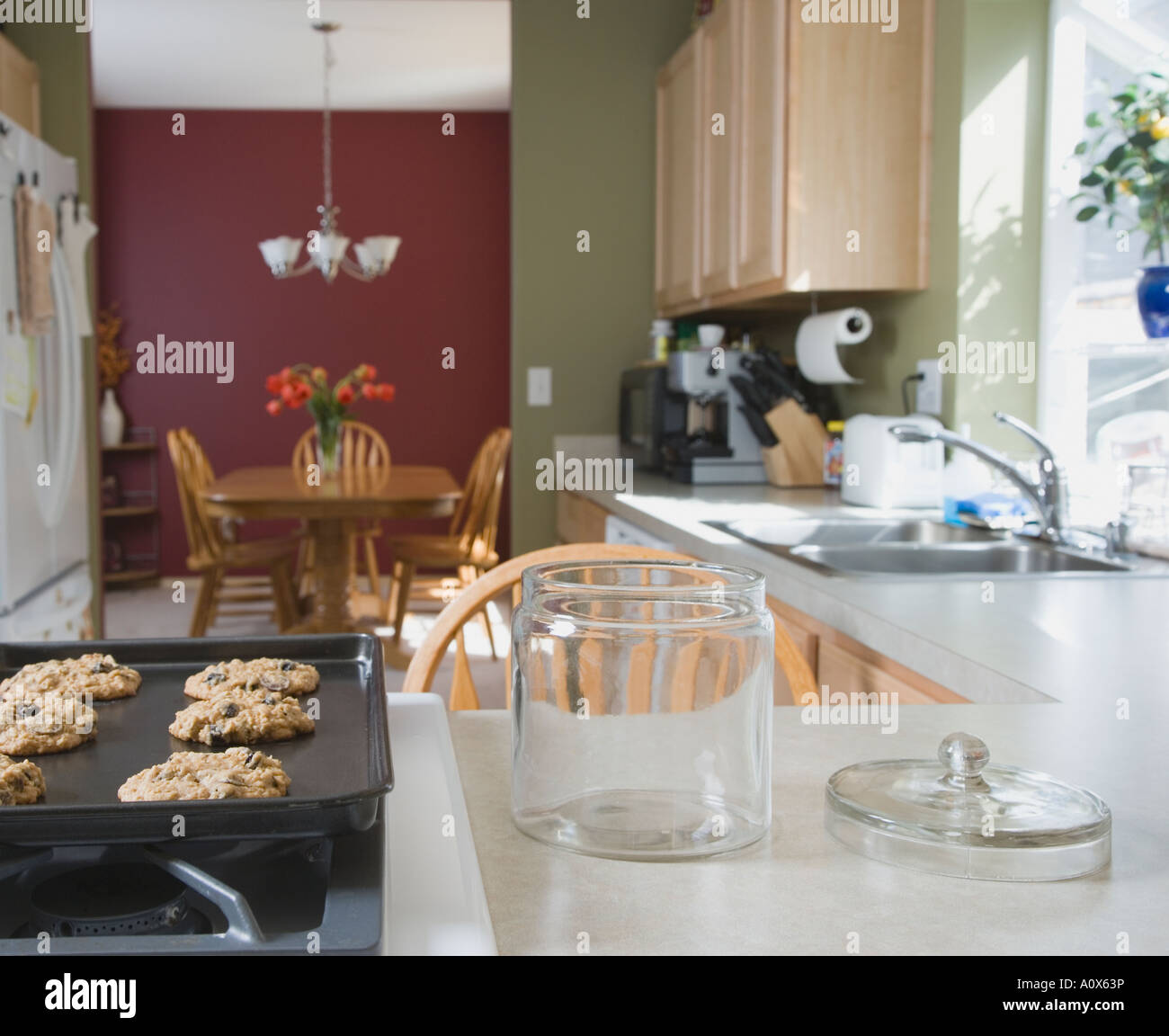 Fresh cookies next to empty cookie jar Stock Photo