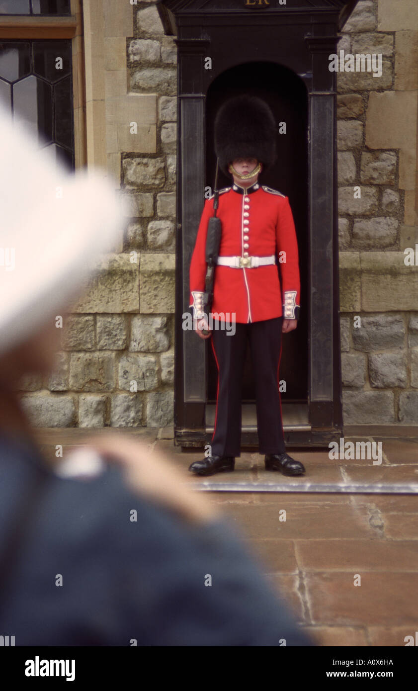 ENGLAND LONDON Tourist with camera stands before a Royal Guard at the Tower of London Stock Photo