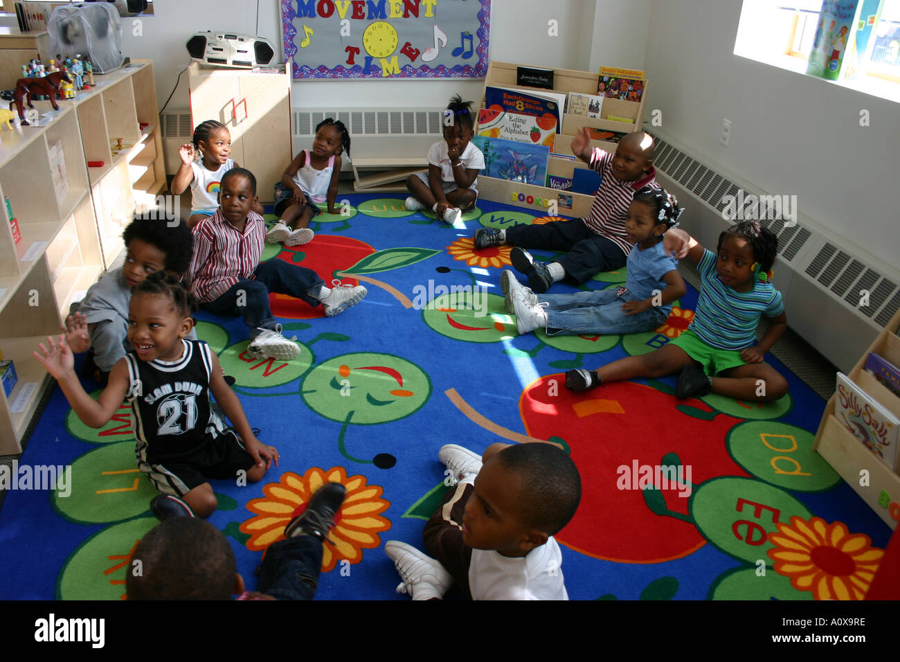 Kindergarten teacher and children looking at book hires stock