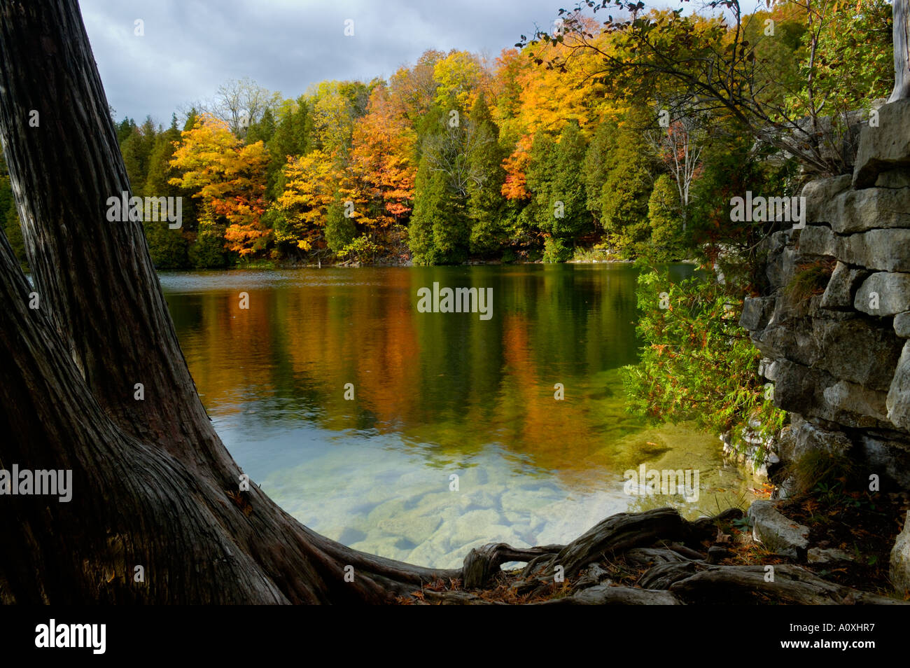 Fall colored trees reflected off Crawford Lake Ontario Canada Stock Photo
