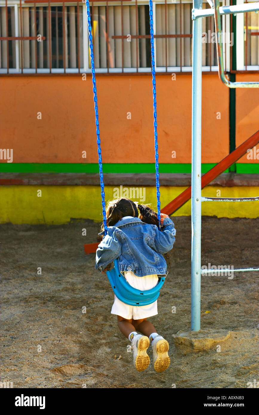 MEXICO Cabo San Lucas Young Mexican girl on swing on preschool