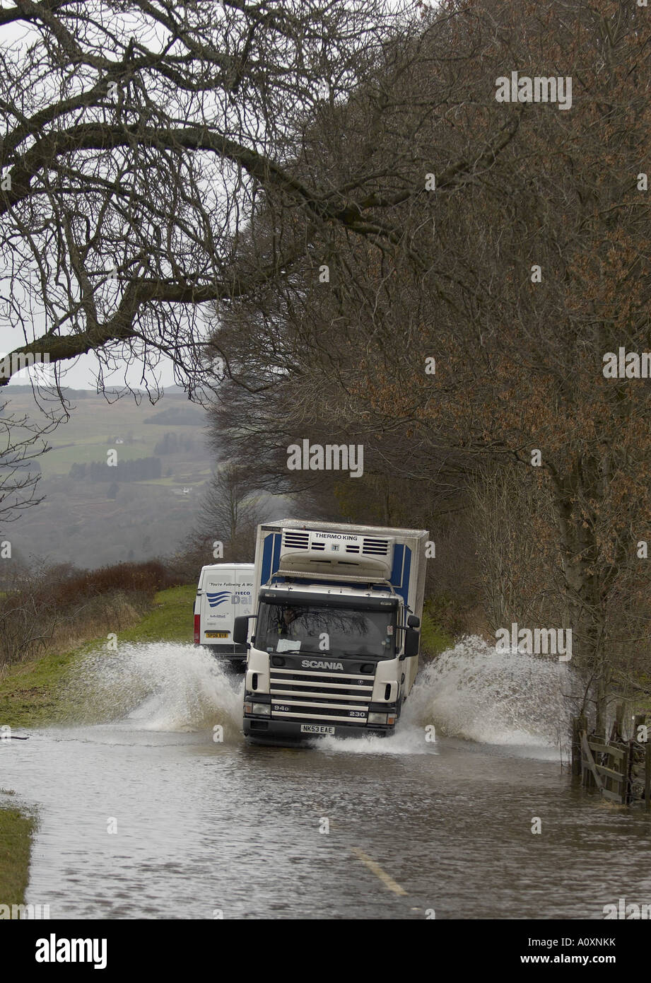 Lorry travelling on flooded road Stock Photo