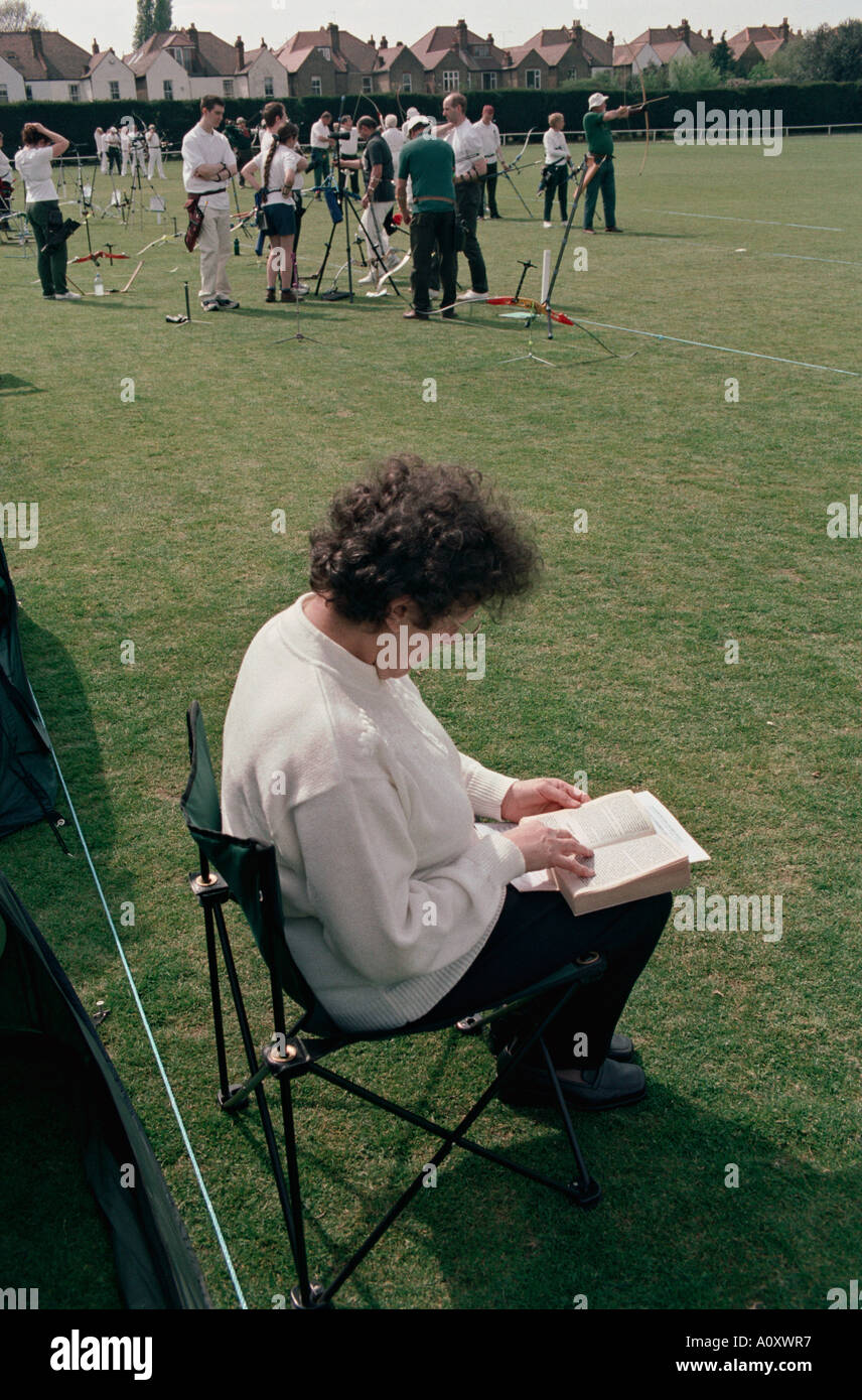 UK ENGLAND A spectator reading a book at an archery contest held at the