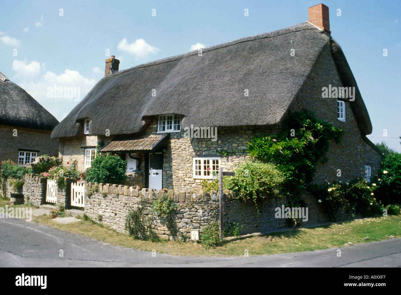 A Traditional Old English Thatched Roof Cottage Set In A Rural