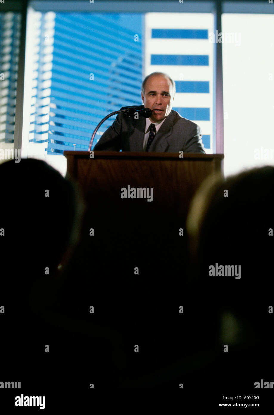 Businessman giving a speech at a podium Stock Photo - Alamy