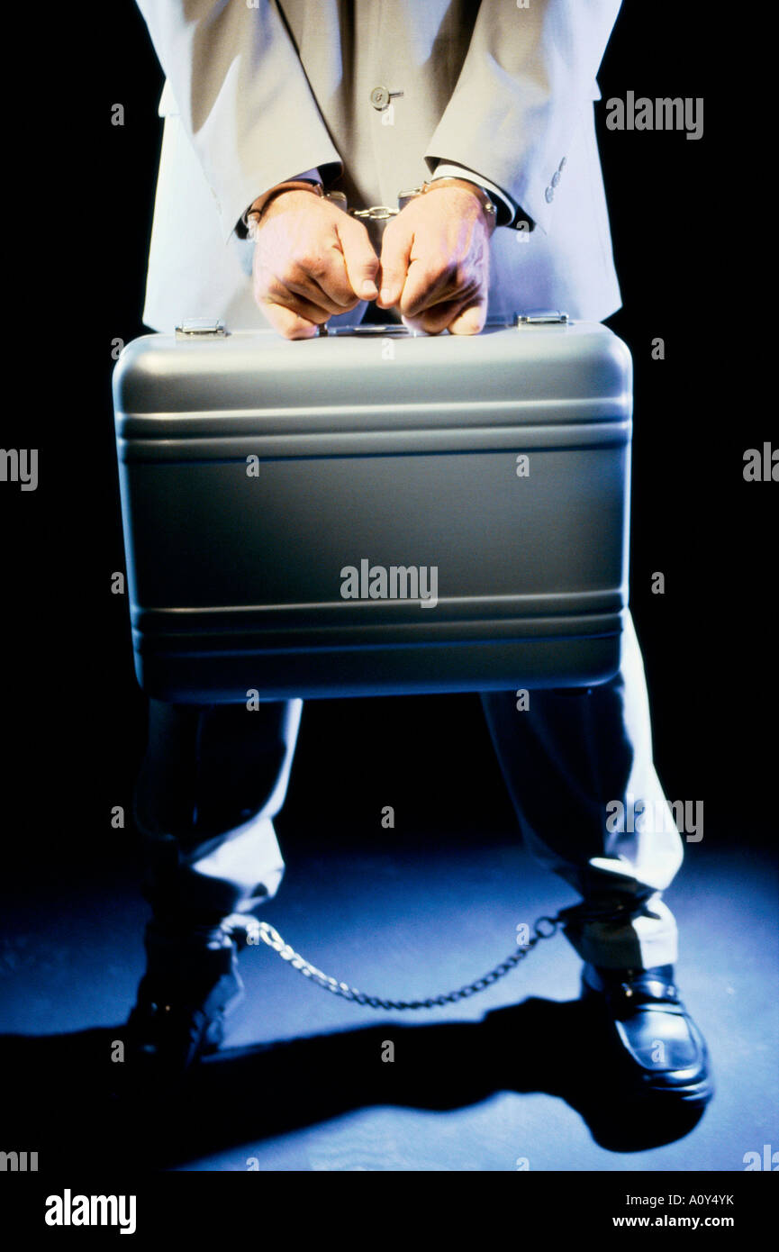Low section view of a businessman holding a briefcase with handcuffs Stock Photo Alamy