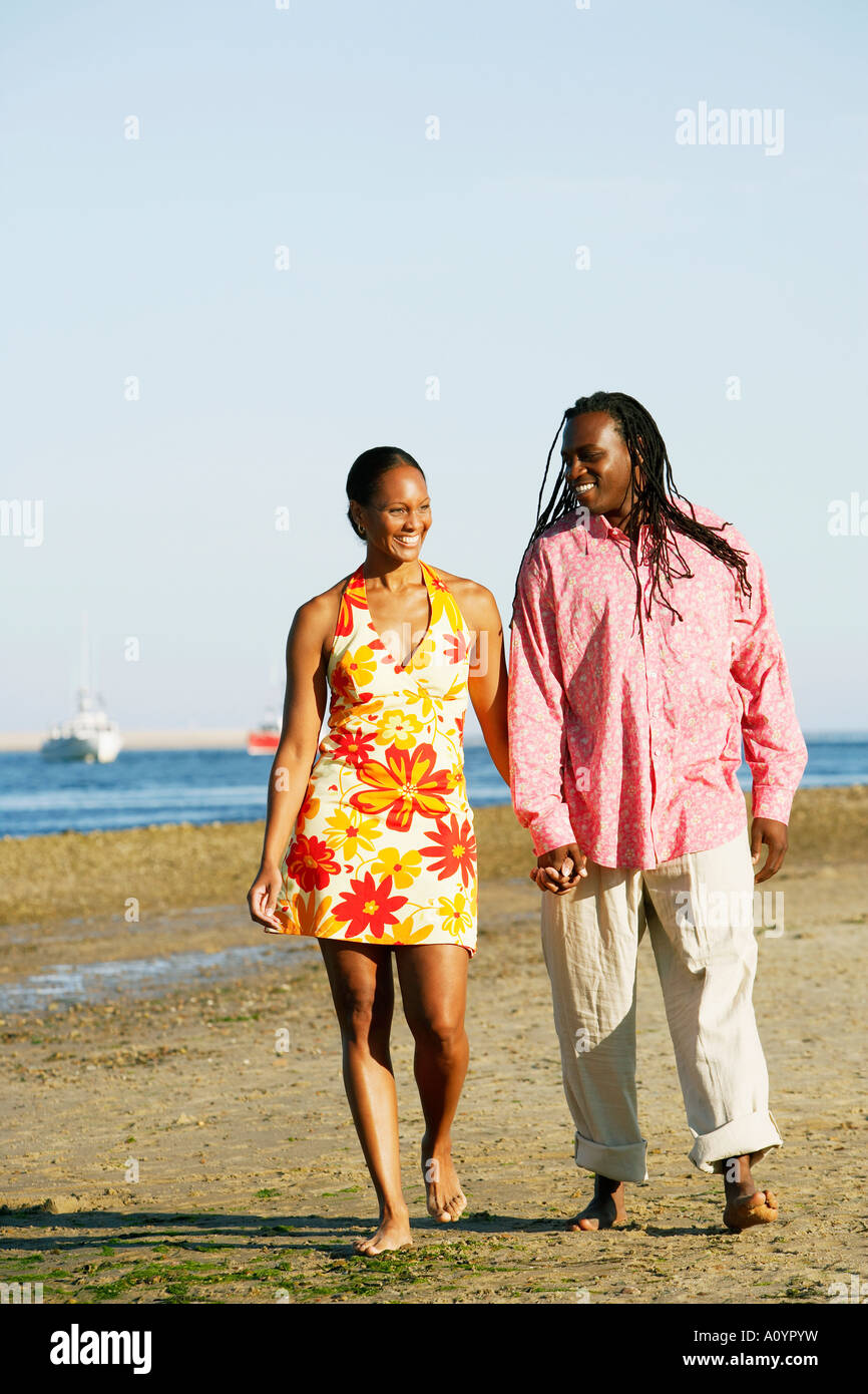 Young African couple walking on the beach hand-in-hand Stock Photo - Alamy