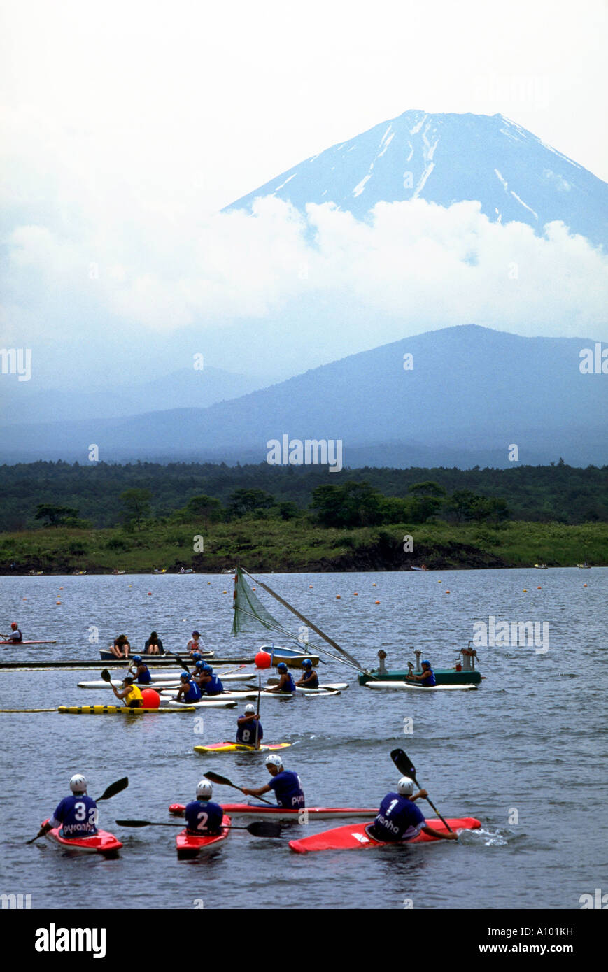 Mount Fuji looming over a group of young kayakers on the waters of Lake Shoji smallest of the group of lakes comprising the Fuji Five Lakes a recreation centre in the Fuji Hakone Izu National Park Stock Photo