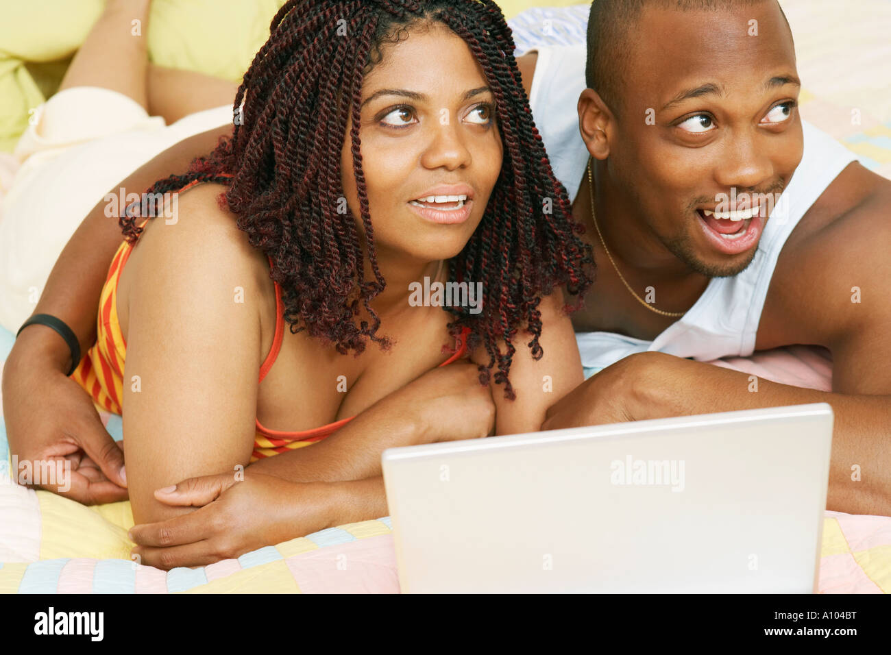 African couple using a laptop in their bedroom Stock Photo - Alamy