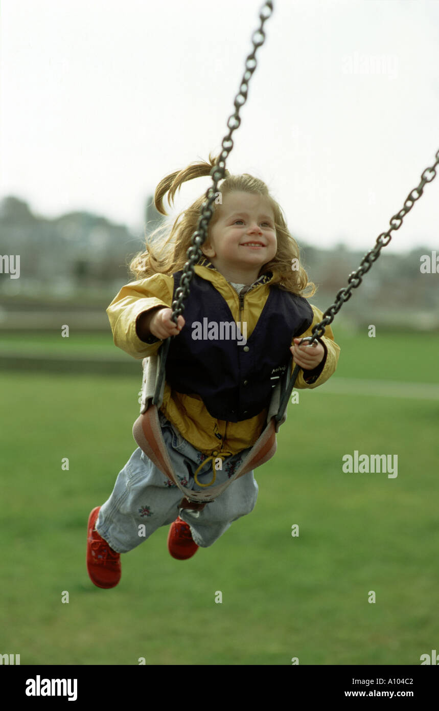 3 three years old girl on a swing at playground Stock Photo - Alamy