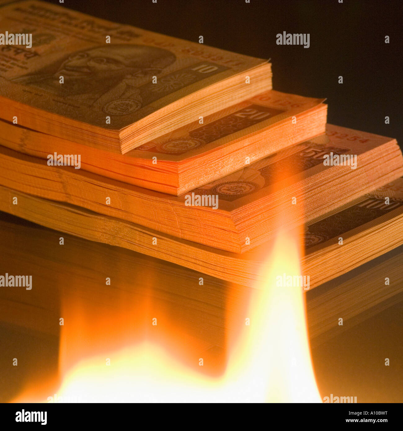 High angle view of a stack of Indian banknotes of different denominations near a flame Stock Photo