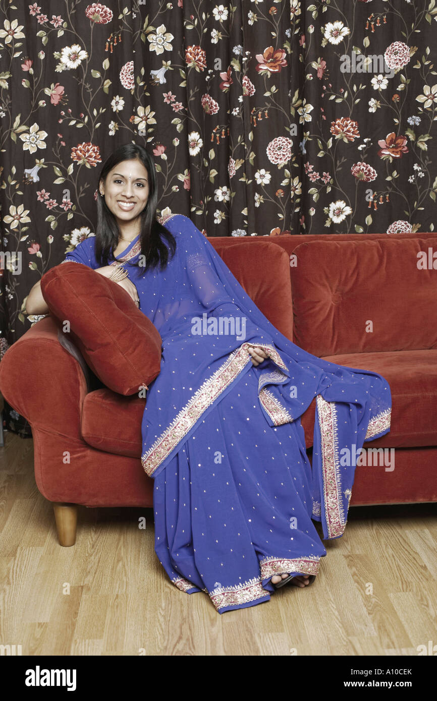 Portrait of a young woman sitting on a couch Stock Photo - Alamy