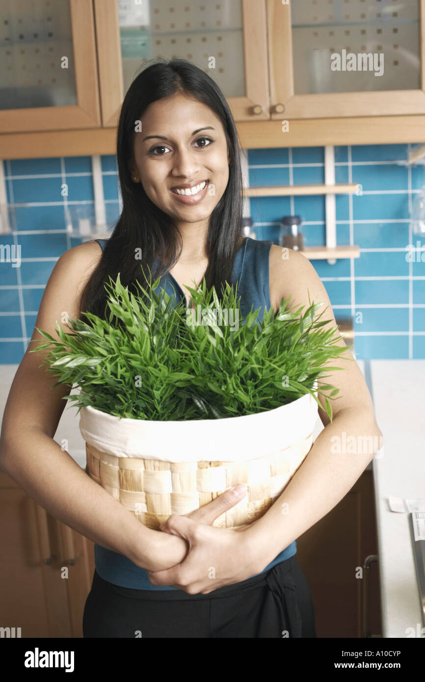 Portrait of a young woman holding a potted plant Stock Photo - Alamy