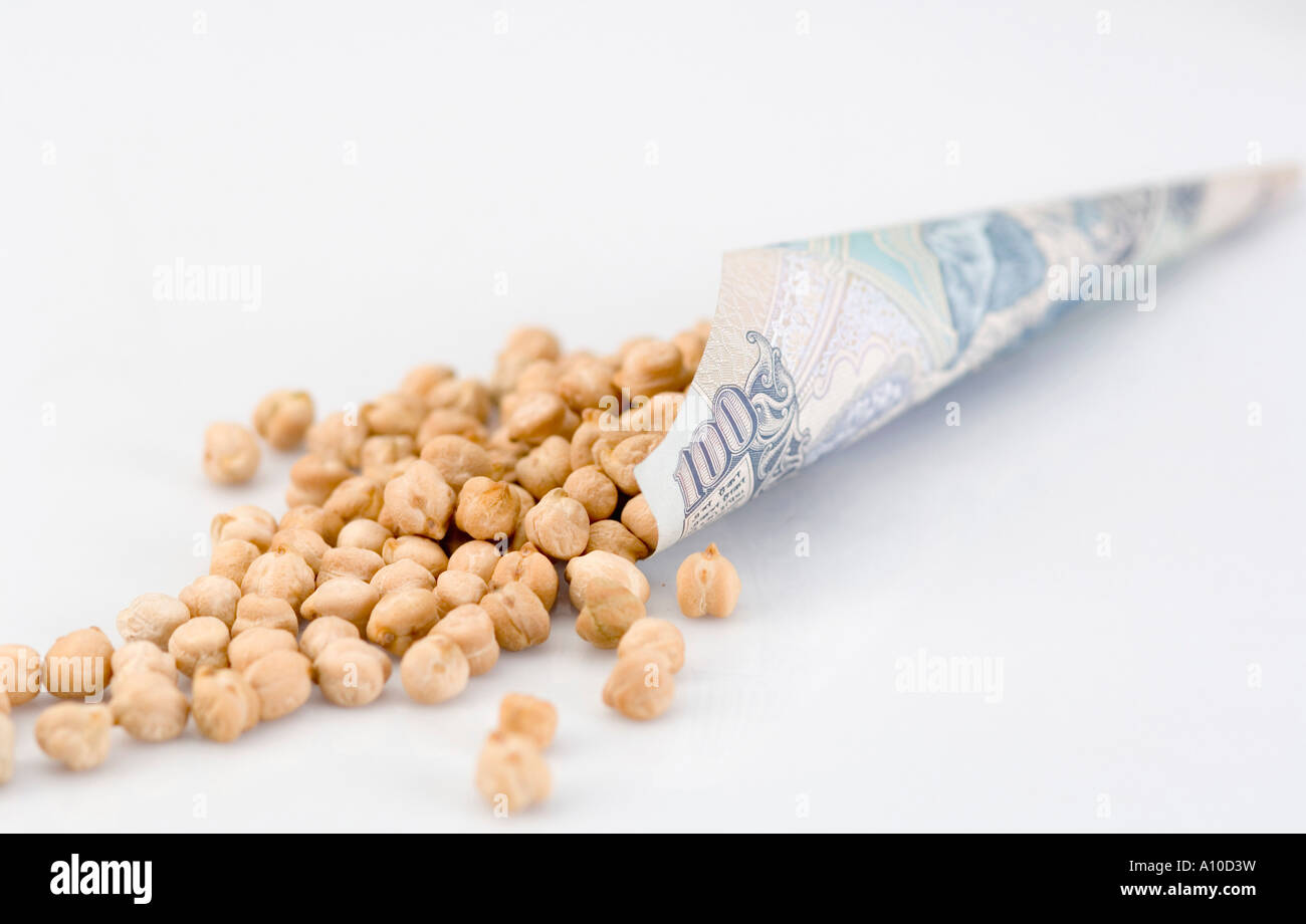 Close-up of Chick-peas spilling out of a cone of an Indian one hundred rupee banknote Stock Photo