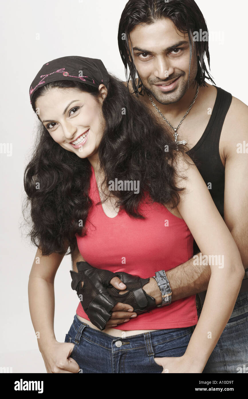 Portrait of a young man embracing a young woman from behind Stock Photo ...