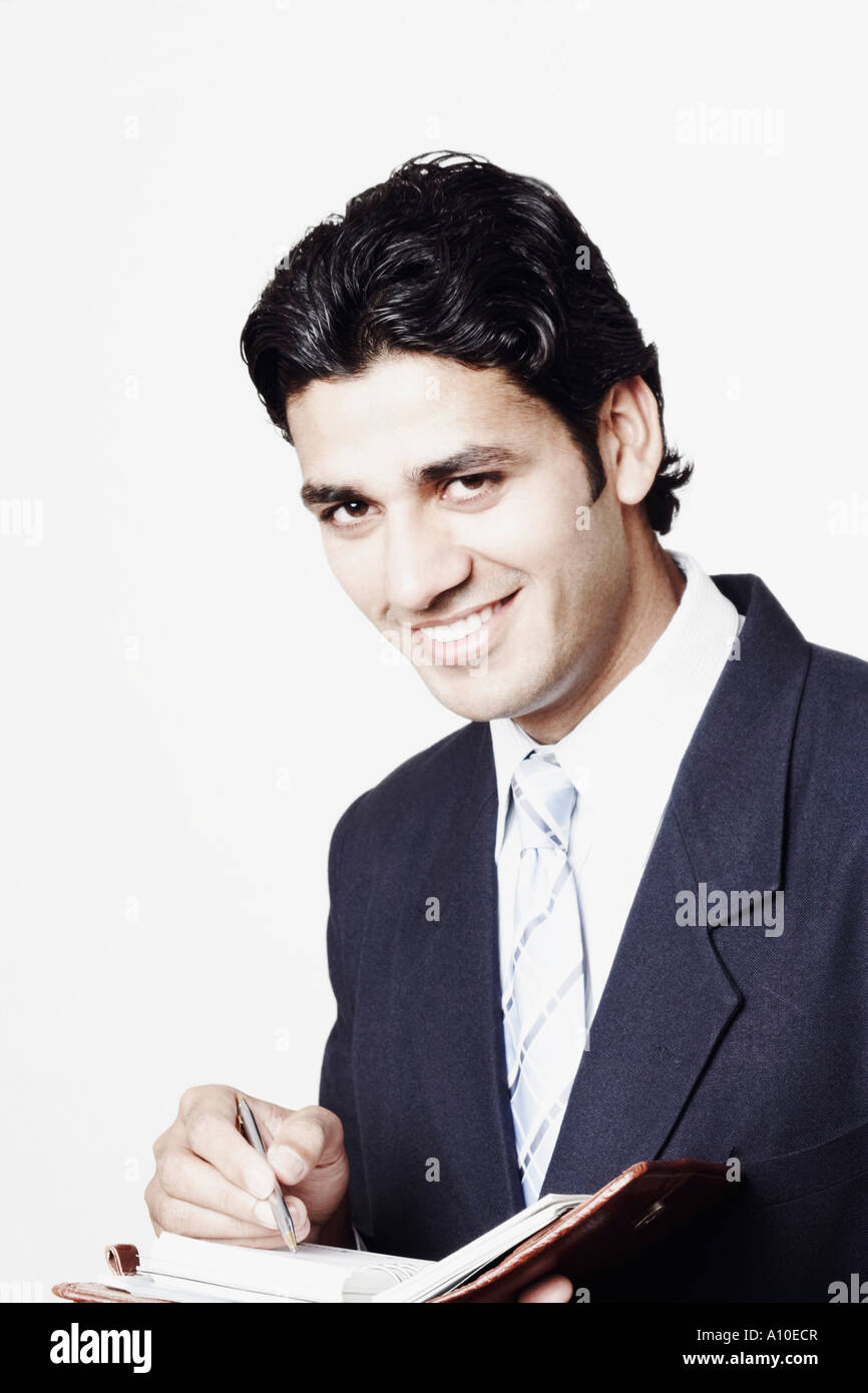 Portrait of a businessman writing in a personal organizer Stock Photo ...