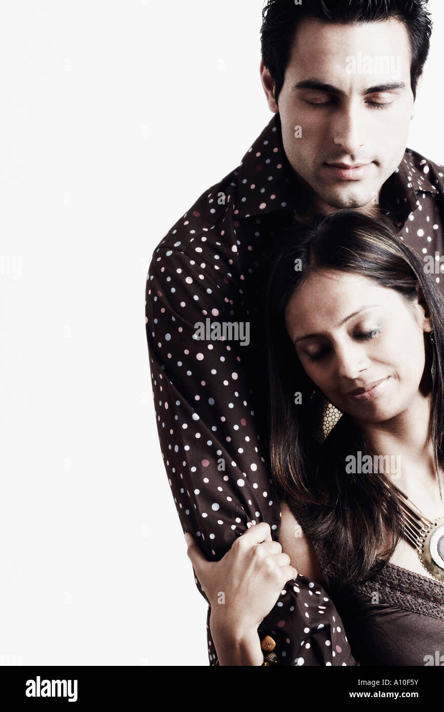 Close-up of a young man embracing a young woman from behind Stock Photo ...