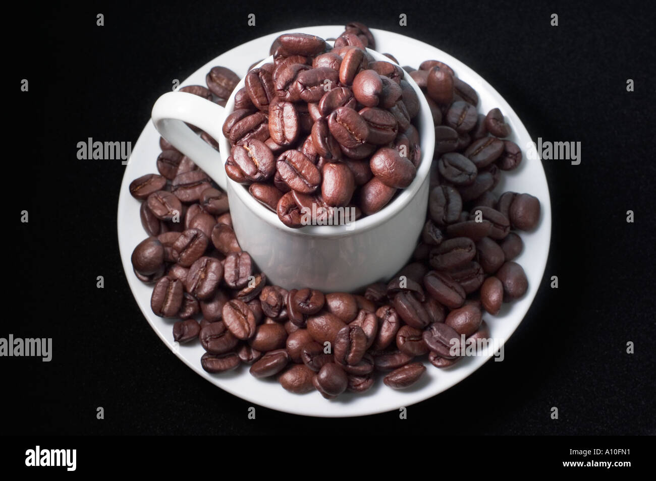 Cup and Saucer Overflowing With Coffee Beans Stock Photo Alamy