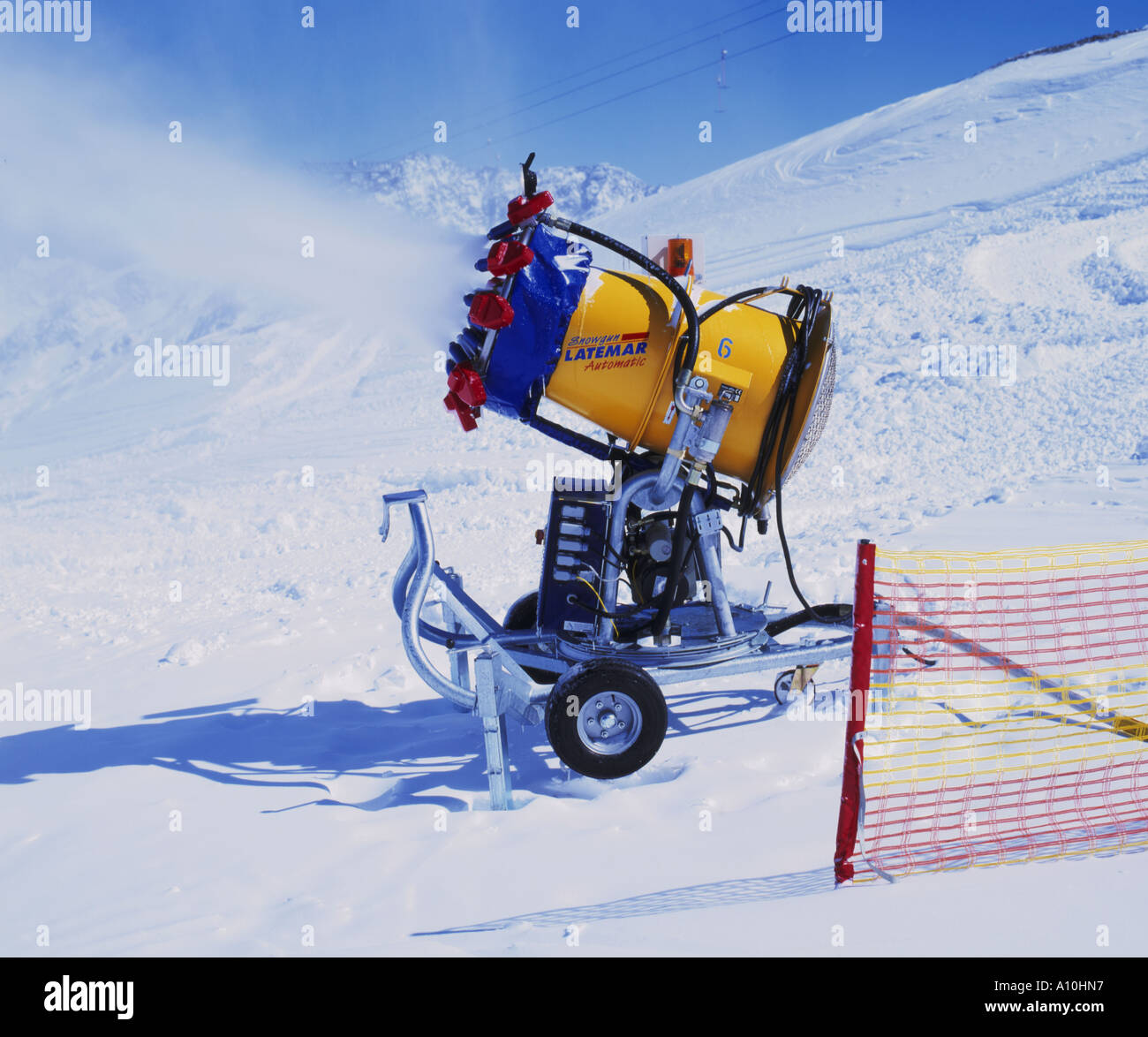 Snow gun spraying artificial snow onto a piste in Austria Stock Photo