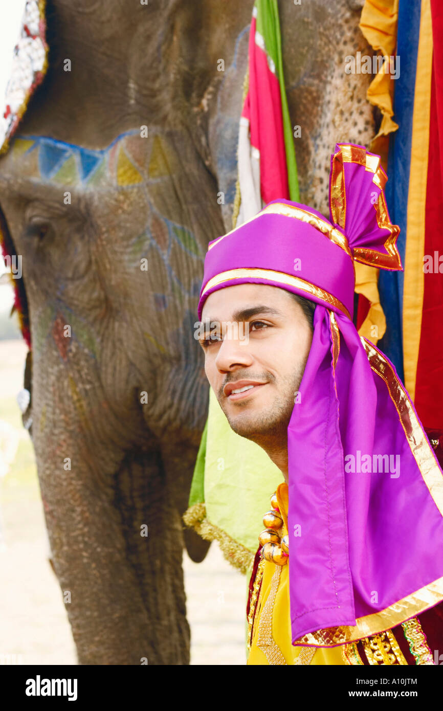 Close-up of a young man standing with an elephant Stock Photo