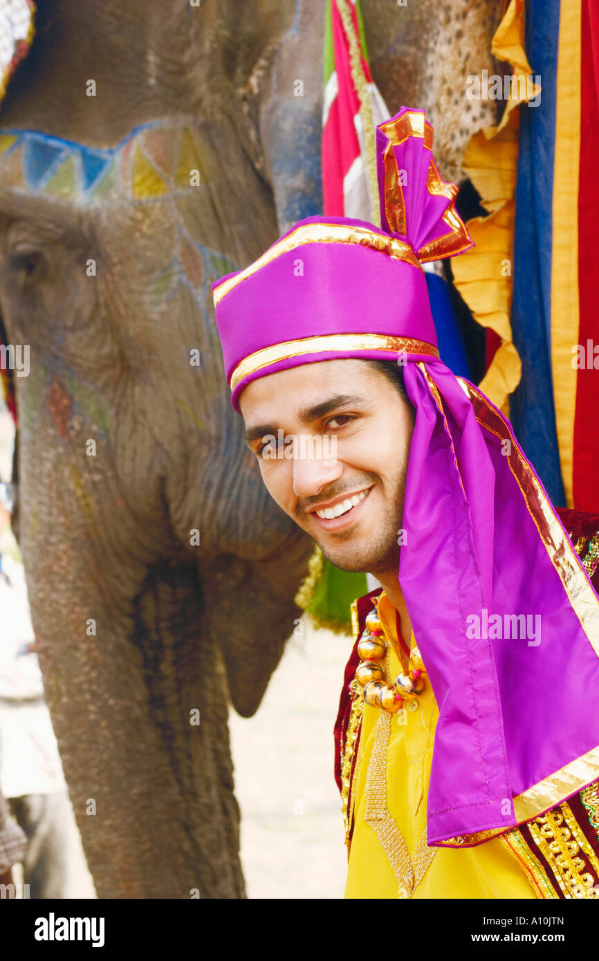 Portrait of a young man standing with an elephant Stock Photo