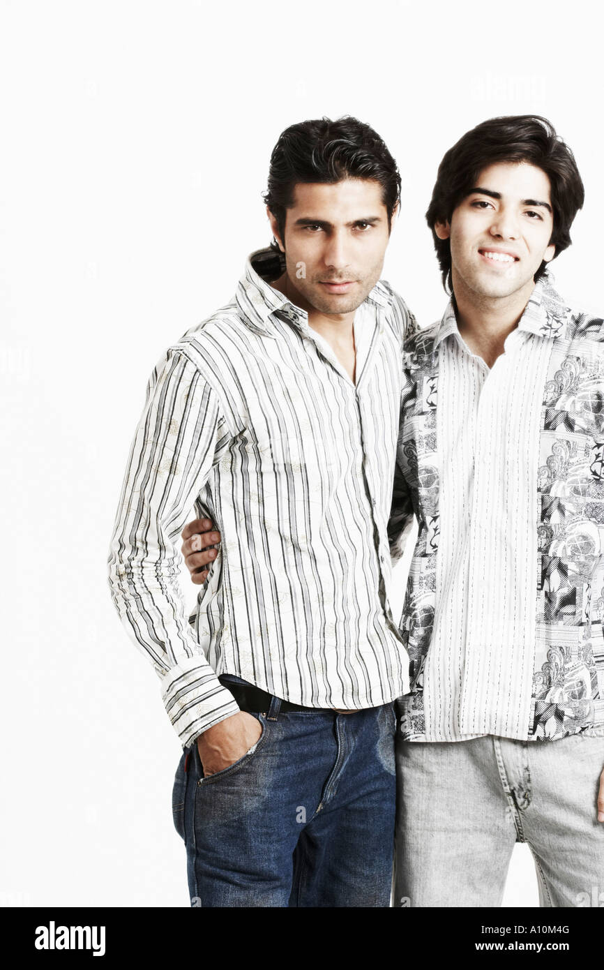 Portrait of two young men standing together with their arms around each ...