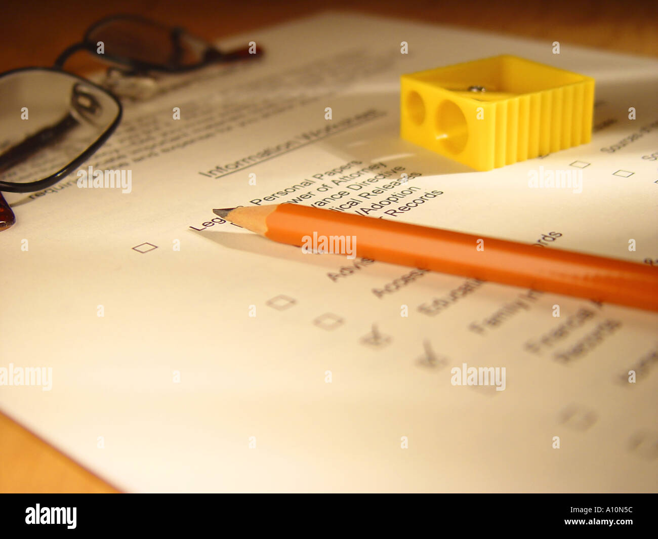 Pencils pencil sharpener and glasses on a check list for organizing