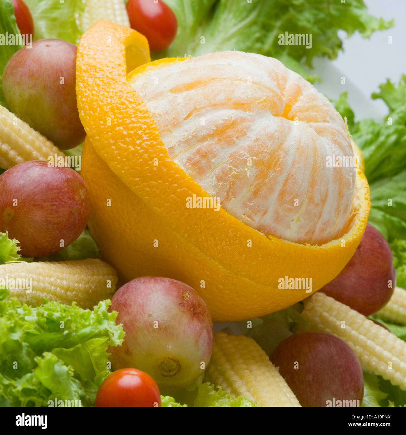Close-up of a peeled orange with baby corns and cherry tomatoes Stock Photo