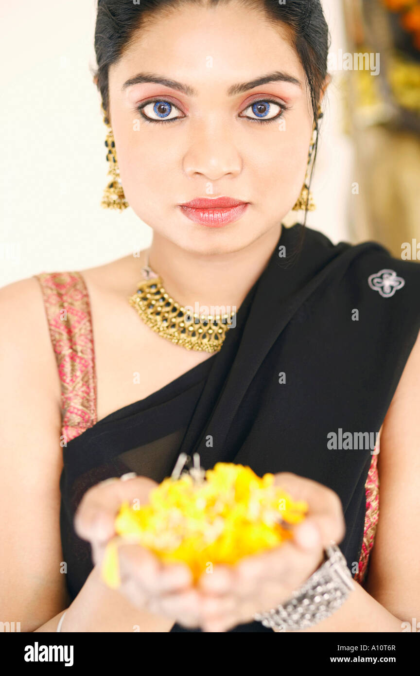 Portrait of a young woman holding flowers in her palm Stock Photo - Alamy