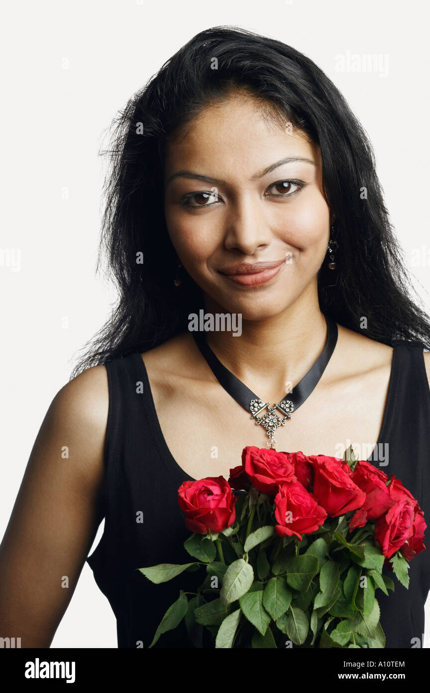 Portrait of a young woman holding a bunch of roses Stock Photo - Alamy