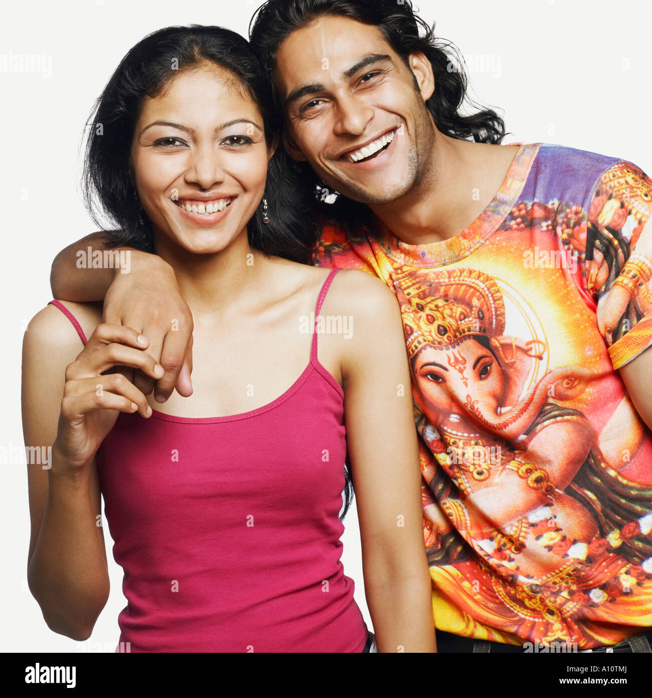 Portrait of a young man standing with his arm around a mid adult woman ...