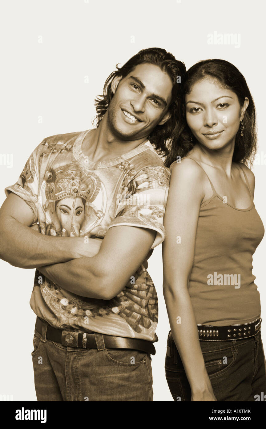 Portrait of a young man standing with a mid adult woman and smiling ...