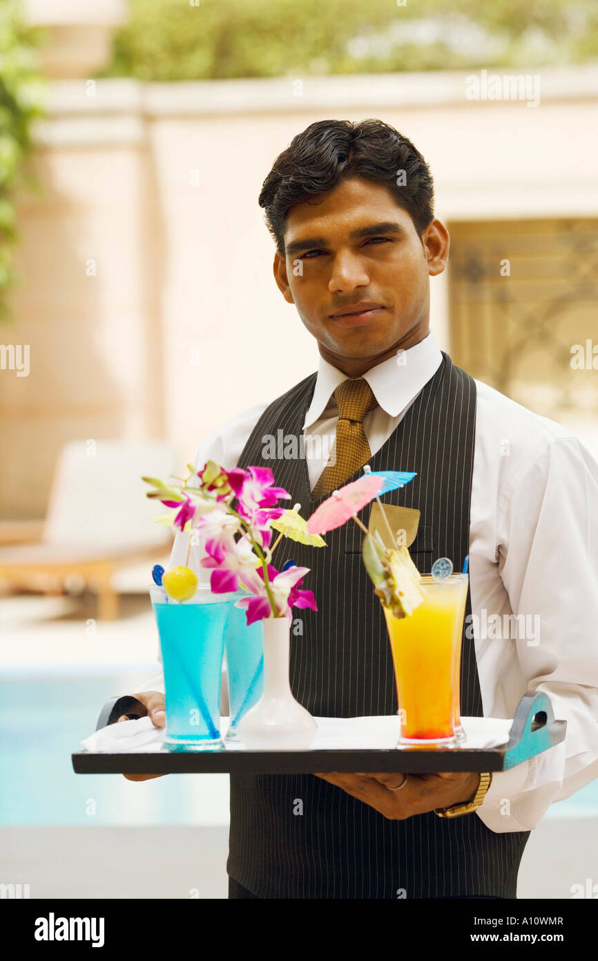 Portrait of a waiter holding a tray of drinks Stock Photo Alamy