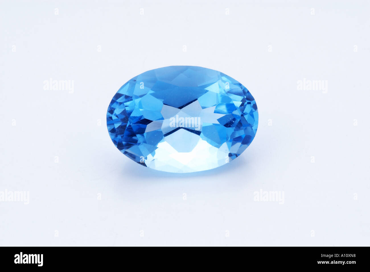 One piece of Blue Quartz Semi Precious Stone oval shape on white paper shining cut facet like crystal expensive value envy Stock Photo