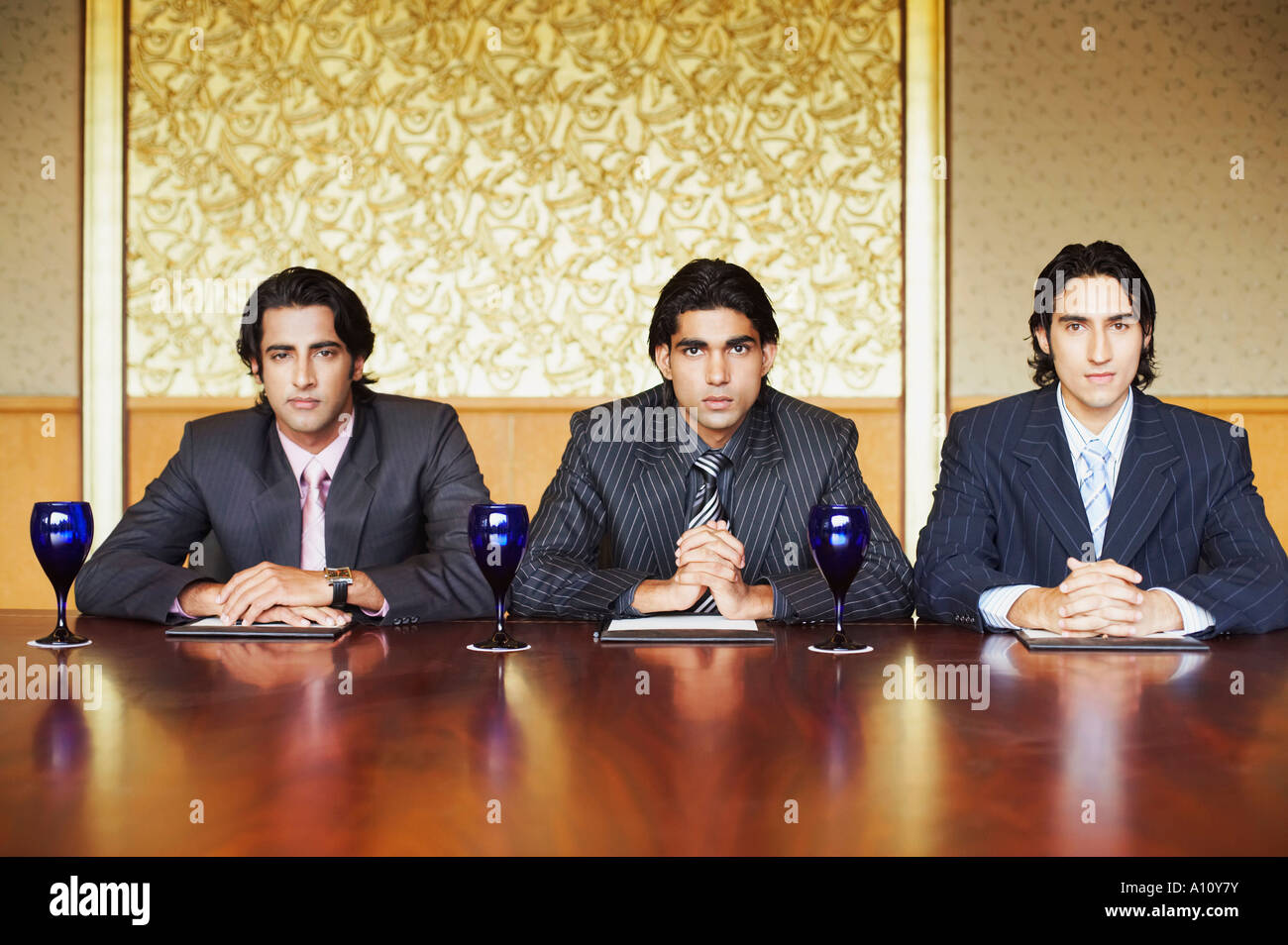 Portrait of three businessmen sitting in a conference room Stock Photo ...