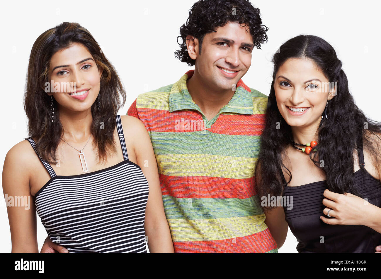 Portrait of a young man standing with two young women Stock Photo - Alamy