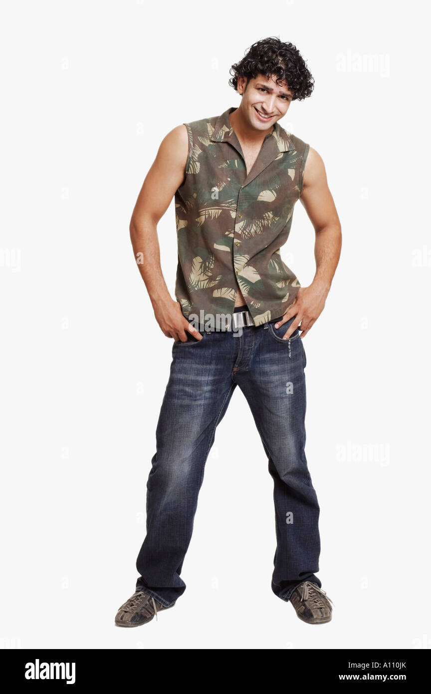 Portrait of a young man standing with arms akimbo Stock Photo - Alamy