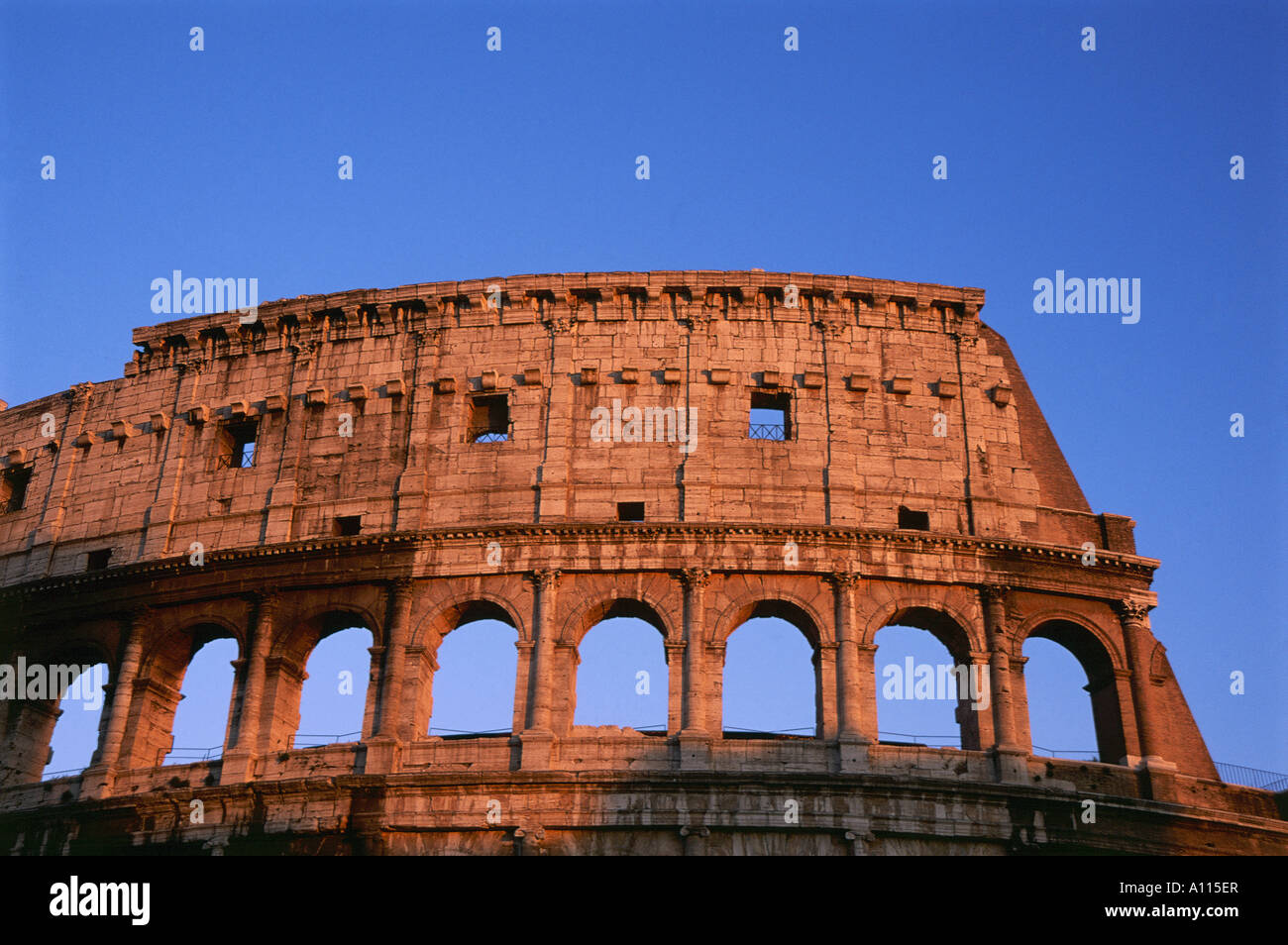 The sun lighting up the top of the Colosseum in Rome Stock Photo