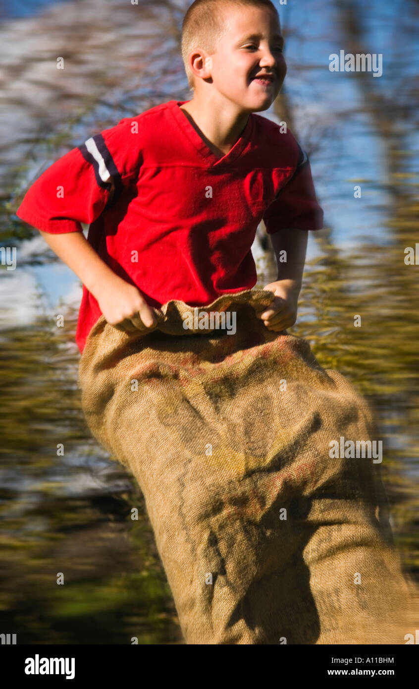 Boy having a gunny sack race Stock Photo Alamy