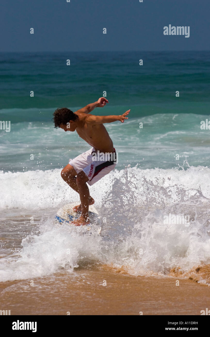 A Skimboarder On Cordoama Beach In Algarve Portugal