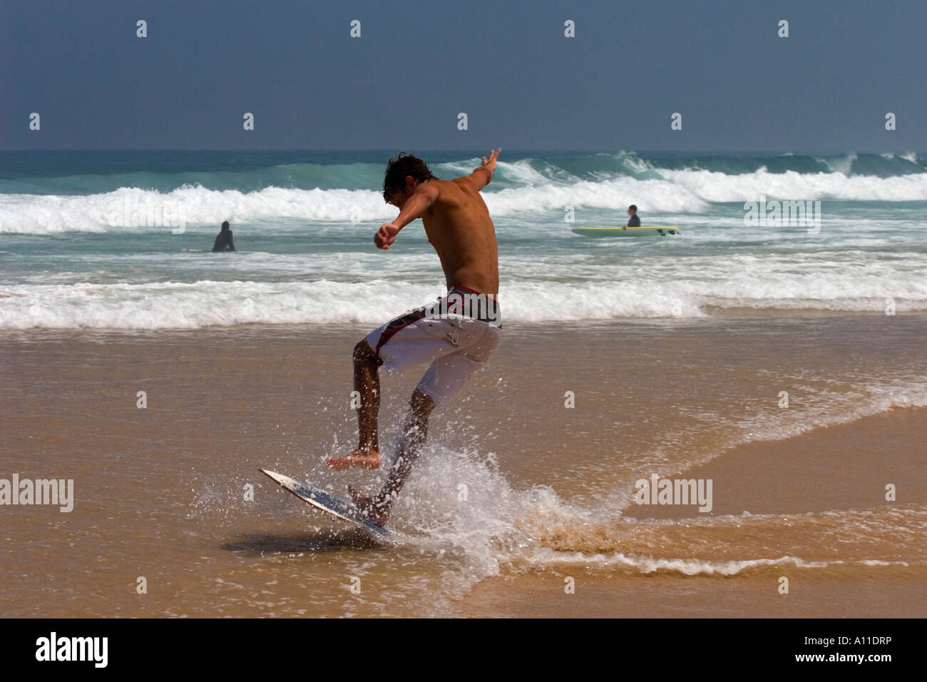 A skimboarder on Cordoama beach, in Algarve (Portugal).  Skimboarder sur la plage de Cordoama, en Algarve (Portugal). Stock Photo