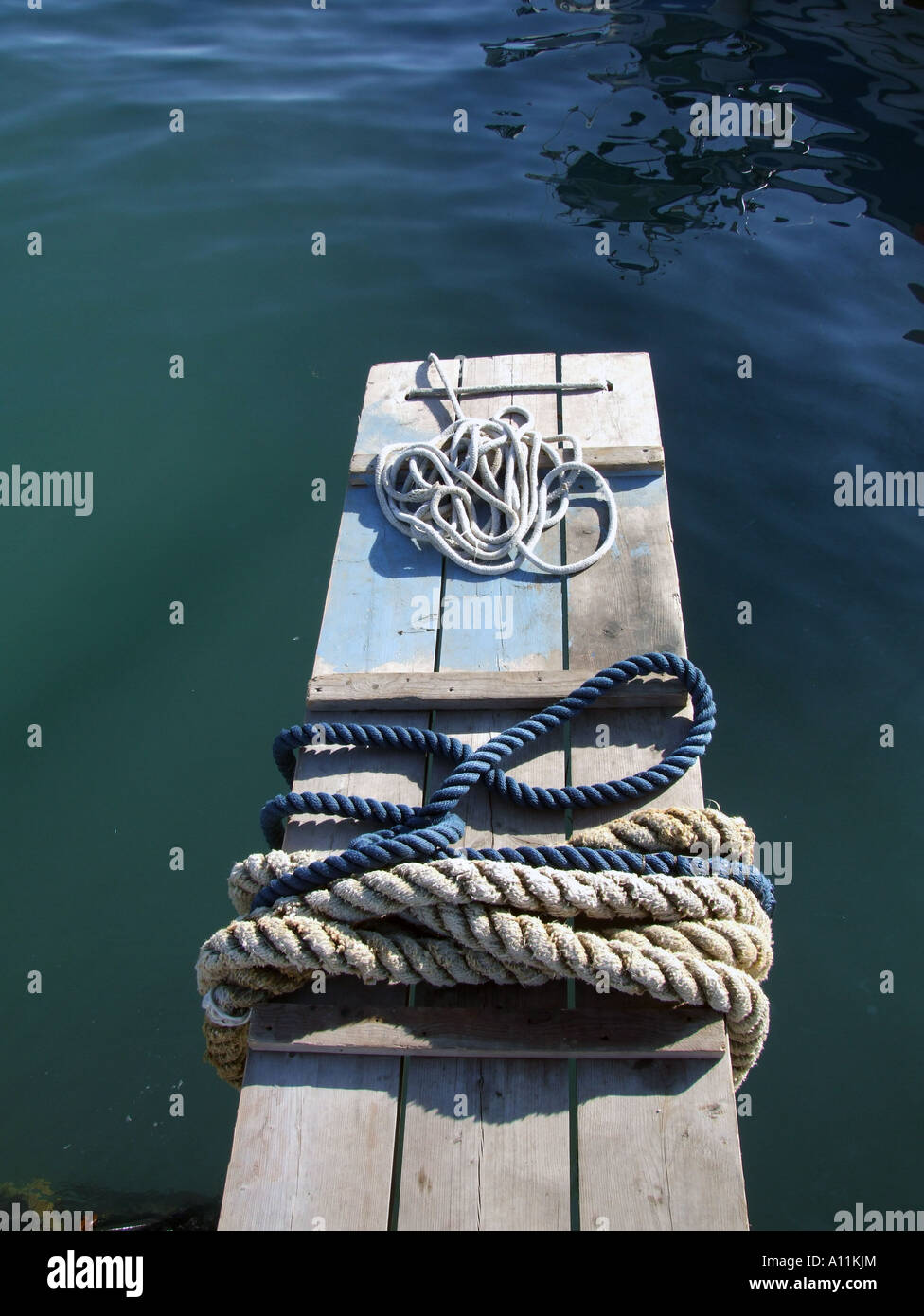https://c8.alamy.com/comp/A11KJM/mooring-ropes-on-small-jetty-by-sea-A11KJM.jpg
