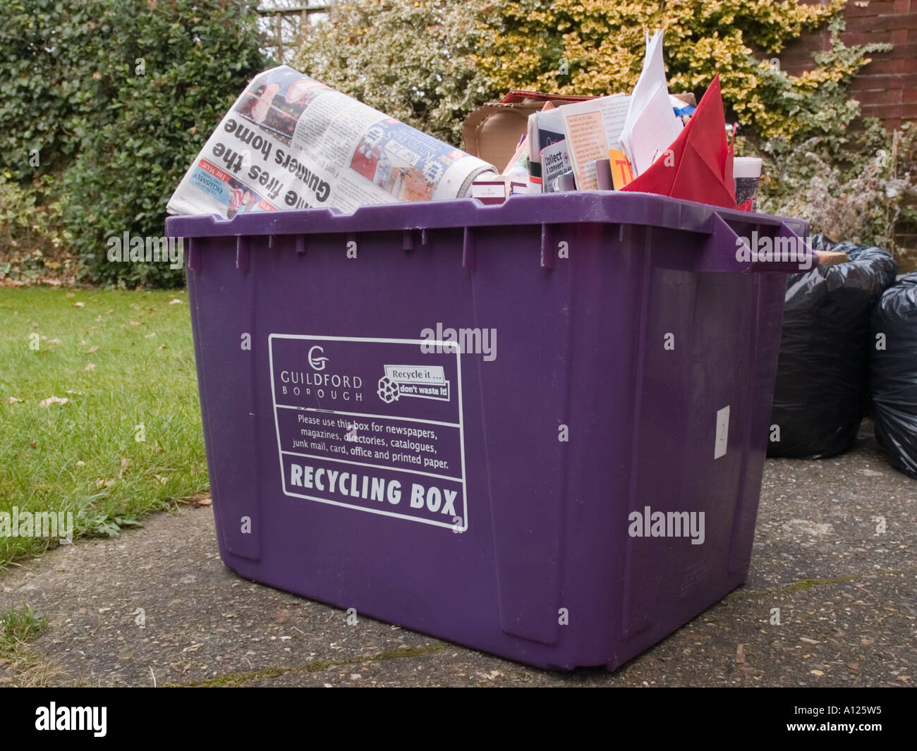 PURPLE RECYCLING BOX issued by Guildford Borough Council full of household waste paper cardboard