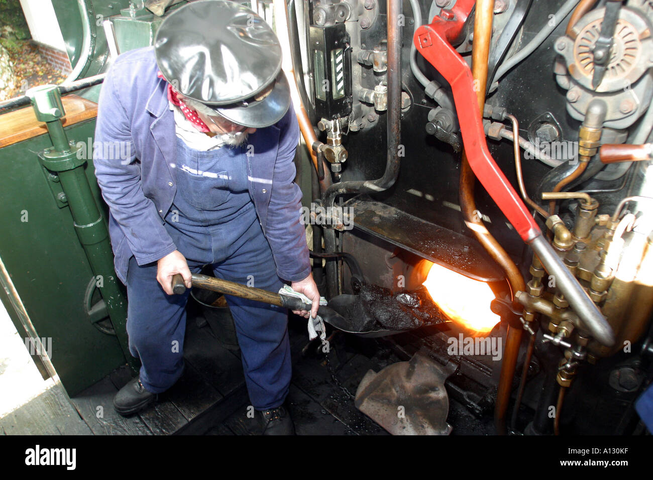 Fireman shovelling coal Bodmin & Wenford Steam Railway Cornwall Stock Photo