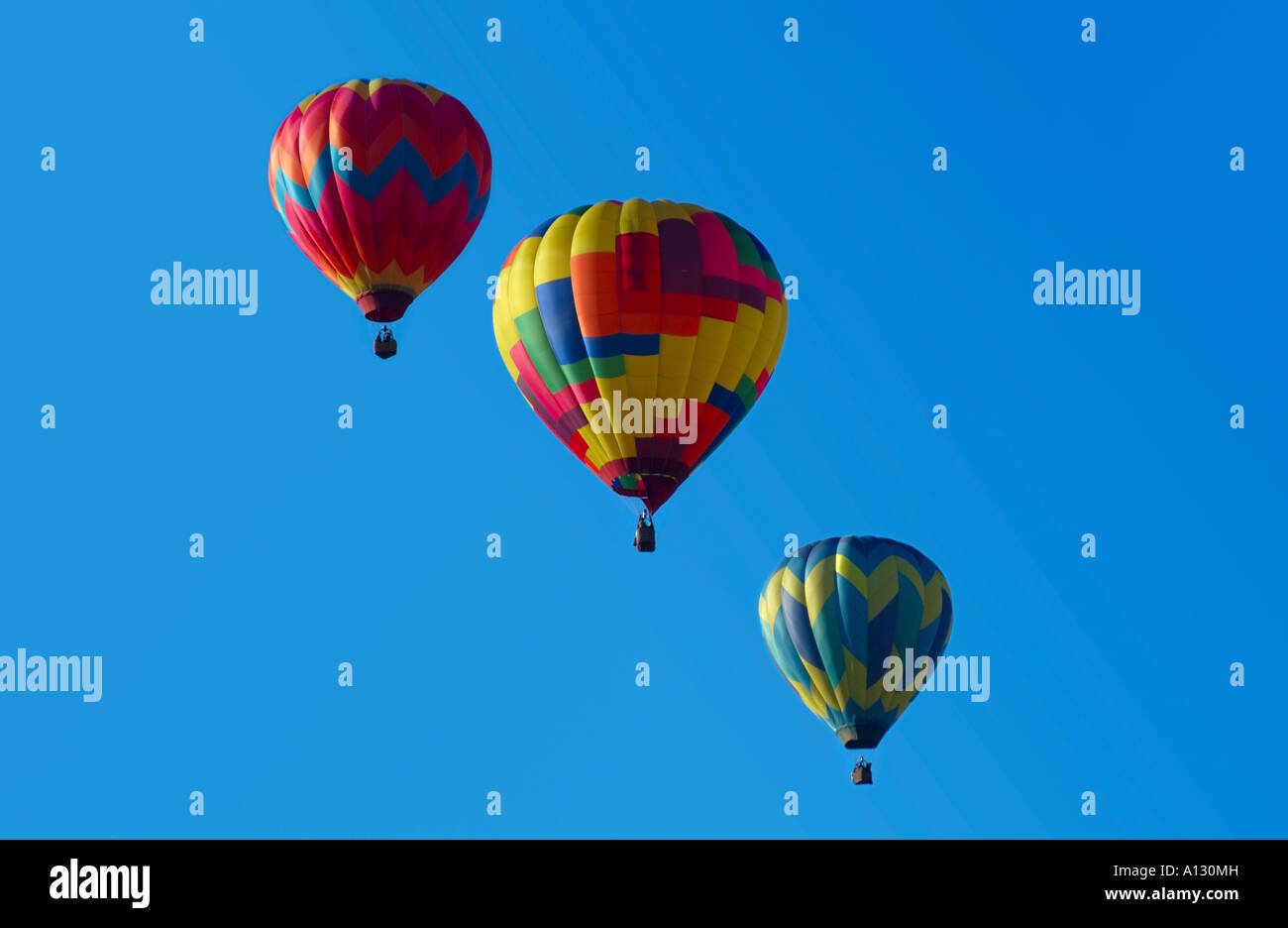 three colorful hot air balloons against a blue sky Stock Photo - Alamy